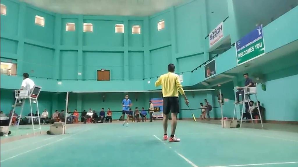 The author playing a badminton match. The author in yellow is serving to the opponent in blue.
